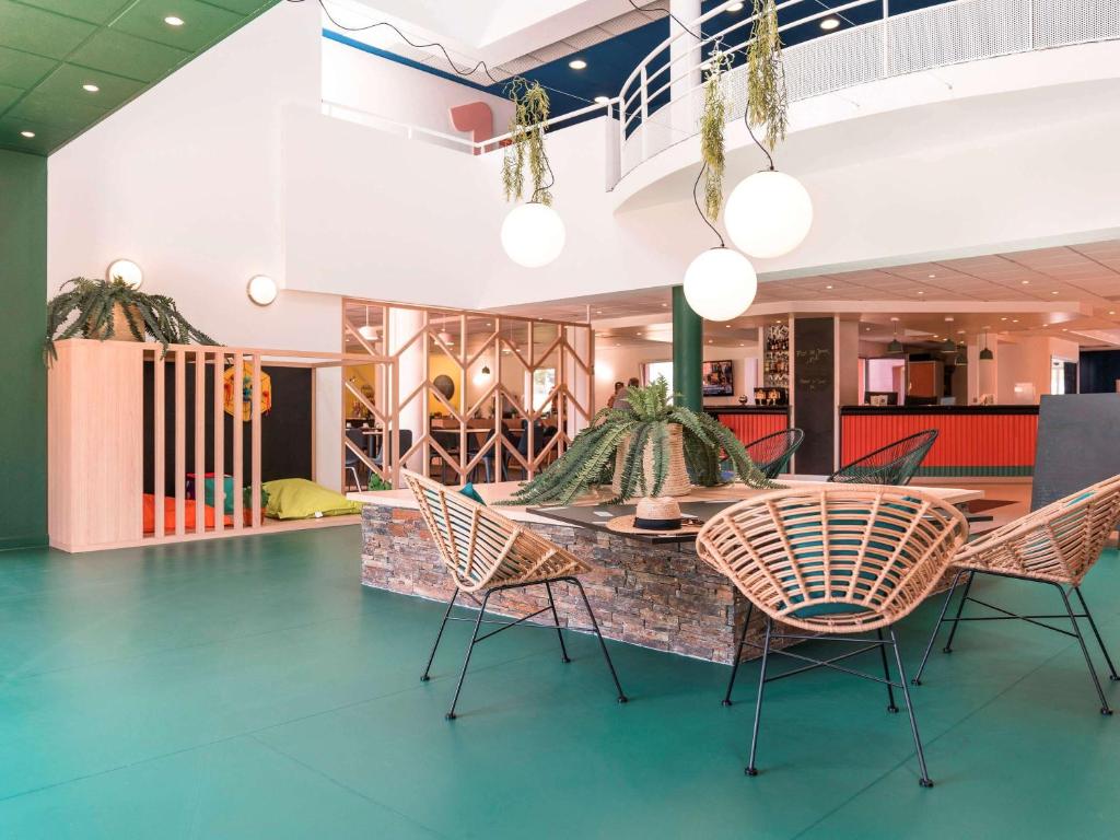 uma sala de jantar com cadeiras e uma mesa num edifício em ibis Styles Marseille Plan de Campagne em Les-Pennes-Mirabeau