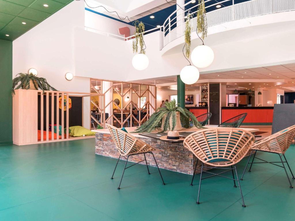 - une salle à manger avec des chaises et une table dans un bâtiment dans l'établissement ibis Styles Marseille Plan de Campagne, aux Pennes-Mirabeau
