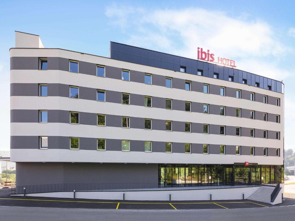 um edifício com uma placa de hotel da HBO em ibis Baden Neuenhof em Baden