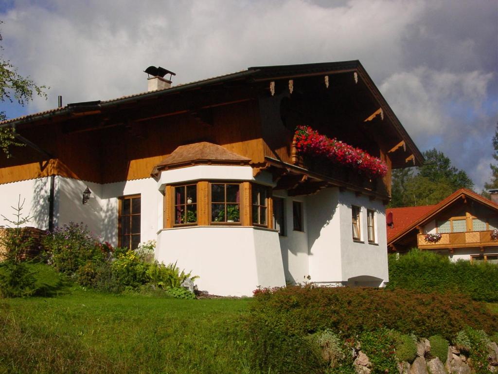 ein kleines Haus mit Blumen im Fenster in der Unterkunft Ferienwohnung Irmgard in Steinberg am Rofan