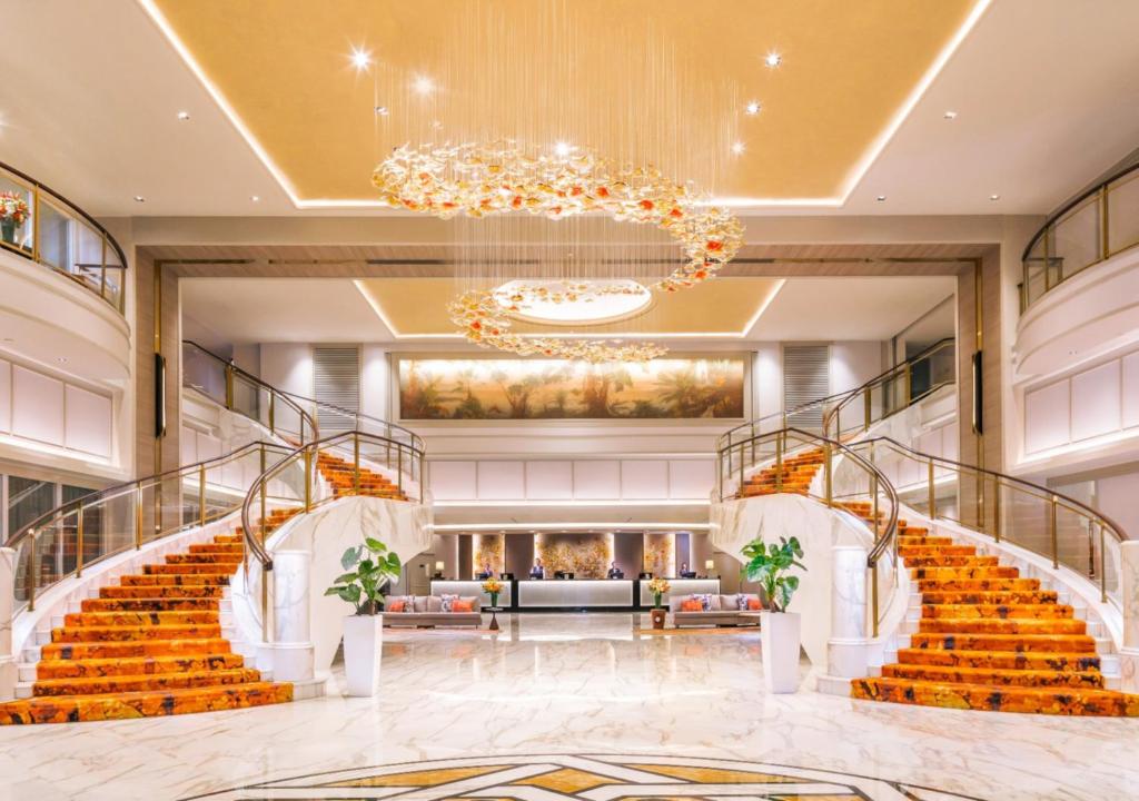eine Lobby mit Treppen und einem Kronleuchter in der Unterkunft Royal Plaza on Scotts in Singapur