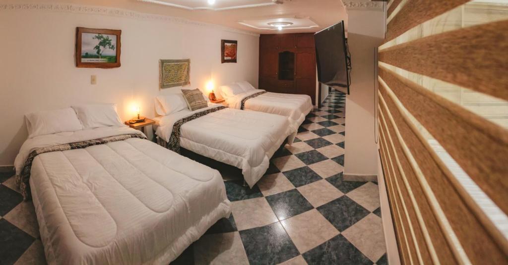 a hotel room with two beds and a checkered floor at NOGAL HOSTEL in Pereira