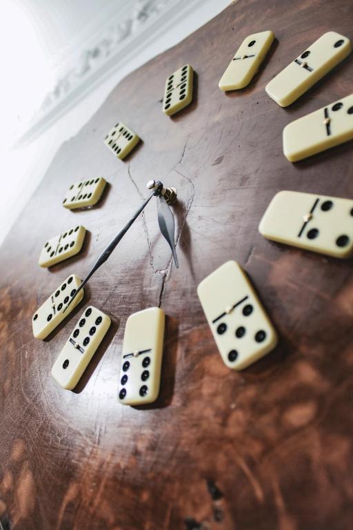 a clock with dominoes on a wooden table at NOGAL HOSTEL in Pereira