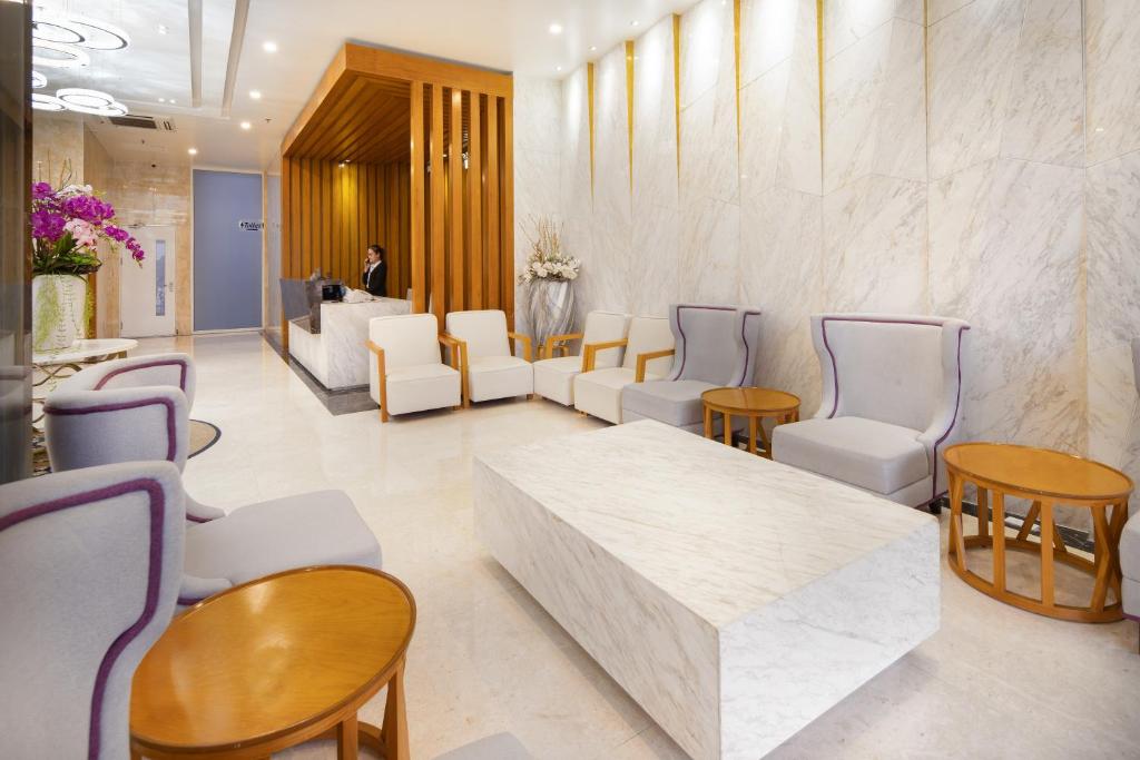 A bright lobby lounge provides several upholstered seats around a large stone coffee table.