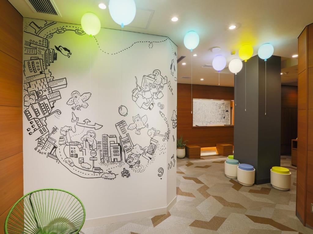 a wall with a drawing of a city at Hotel Wing International Ikebukuro in Tokyo