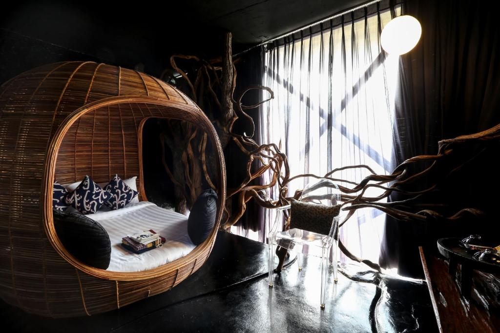 Zimmer mit rundem Rattanbett und Fenster in der Unterkunft Mo rooms in Chiang Mai