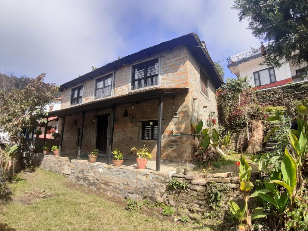 una casa in pietra con piante in vaso di fronte di Siddhartha Garden Ayurveda a Pokhara