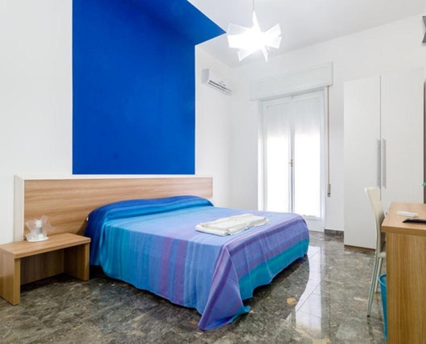 a bedroom with a blue wall and a bed at Porta Nuova in Marsala