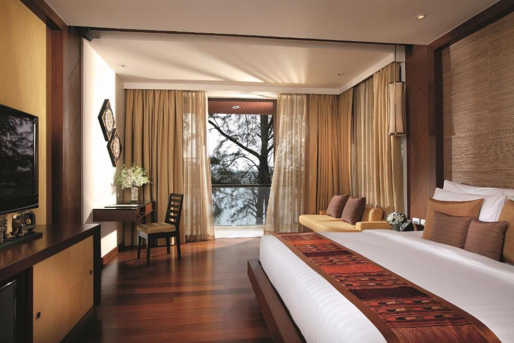 a hotel room with a large bed and a window at Mövenpick Resort Bangtao Beach Phuket in Bang Tao Beach