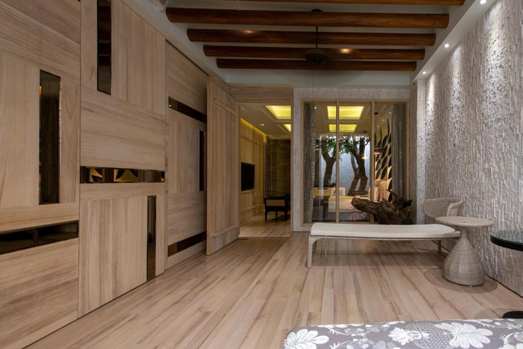 a living room with wooden walls and wooden floors at Blossom Motel in Puxin