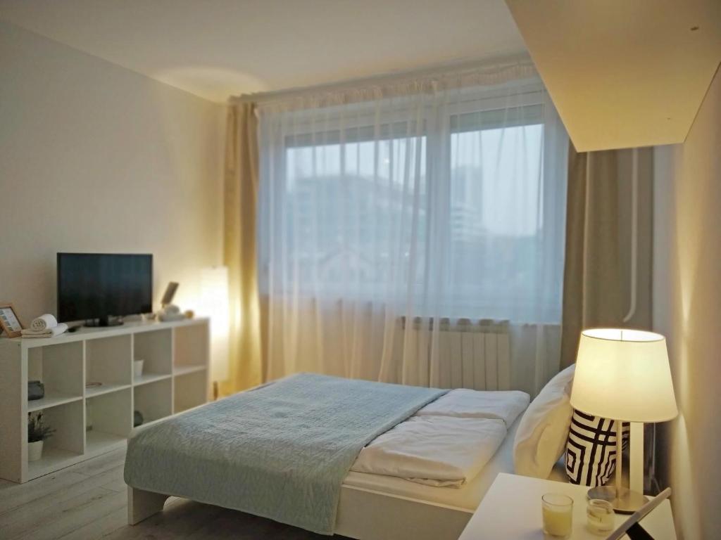 Säng eller sängar i ett rum på White Almond Apartment