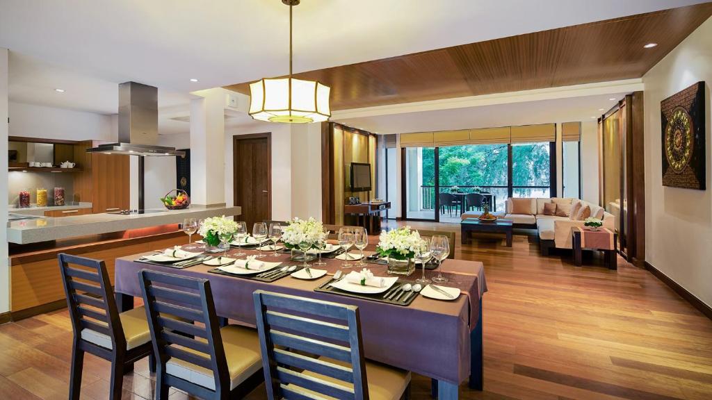a dining room and living room with a table and chairs at Mövenpick Resort Bangtao Beach Phuket in Bang Tao Beach