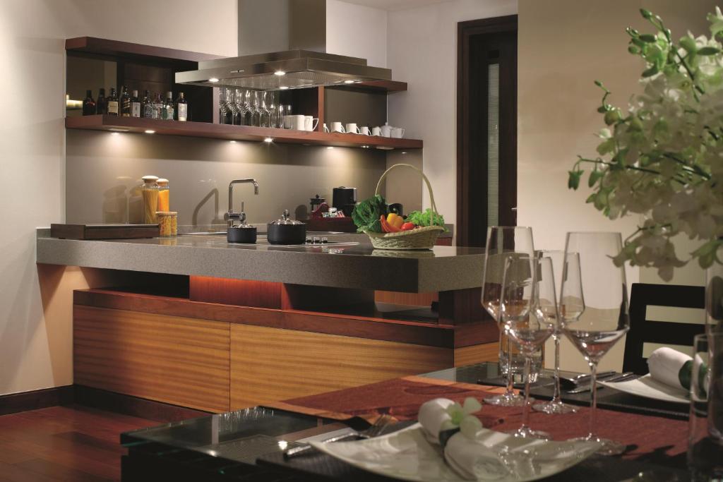 a kitchen with a table with wine glasses on it at Mövenpick Resort Bangtao Beach Phuket in Bang Tao Beach
