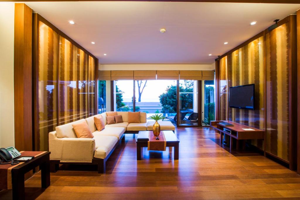 a living room with a couch and a tv at Mövenpick Resort Bangtao Beach Phuket in Bang Tao Beach