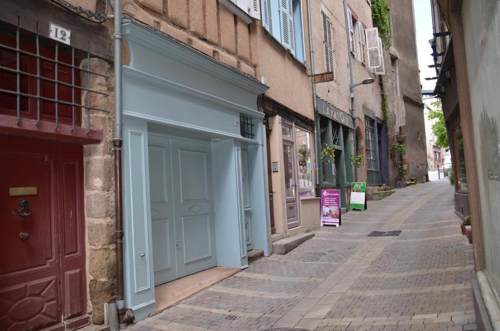 een steegje met een blauwe garage aan de zijkant van een gebouw bij La Maison bleue, un emplacement de choix à Rodez in Rodez