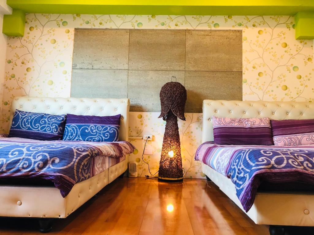 a bedroom with two beds and a lamp in it at Chong Er Ya She Homestay in Jiji