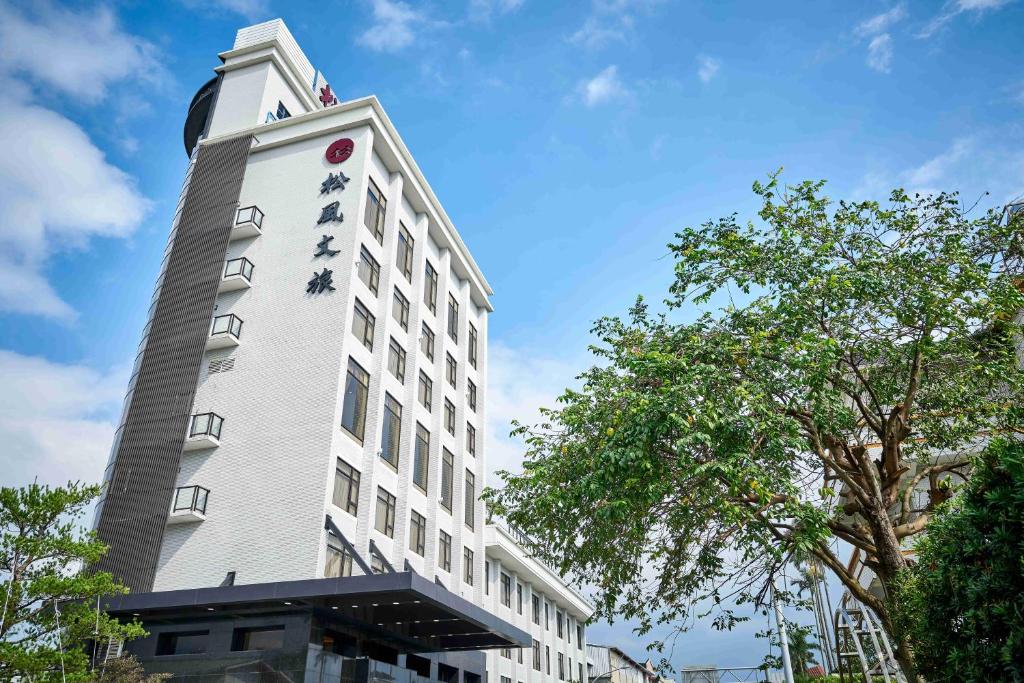 um edifício branco alto com um cartaz em So Fun Hotel em Wujie