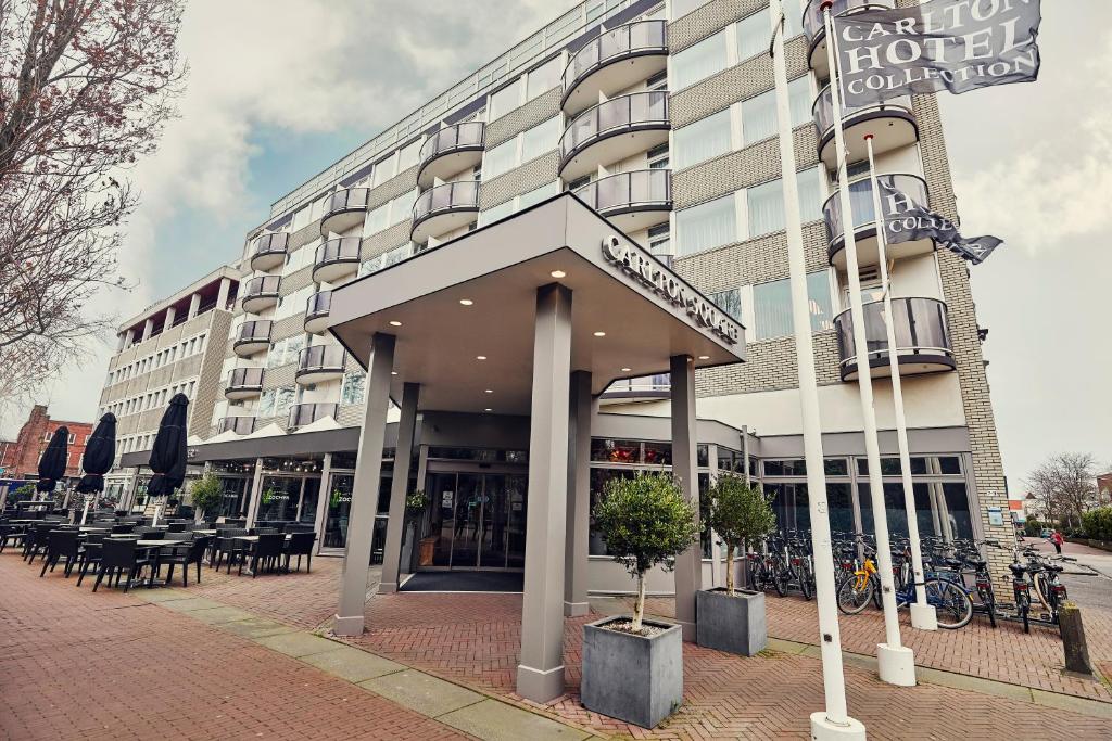 ein Hotel mit Tischen und Stühlen vor einem Gebäude in der Unterkunft Carlton Square Hotel in Haarlem