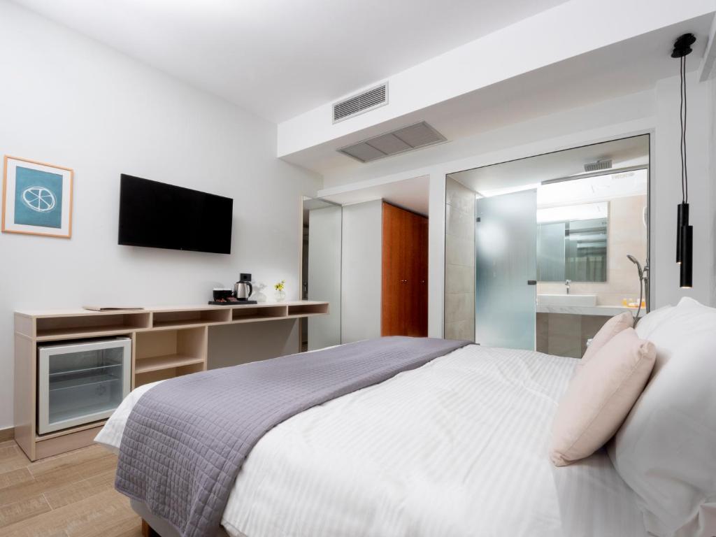 1 dormitorio con 1 cama grande y TV en Athena Hotel en Rodas