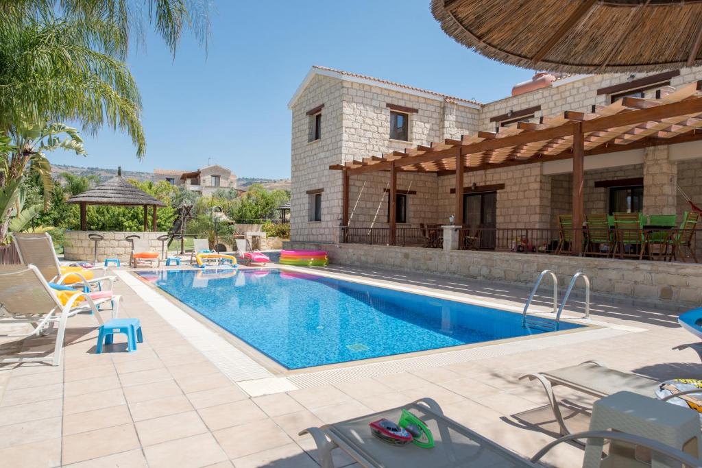 a swimming pool in front of a house at Stephanie Villa in Simou