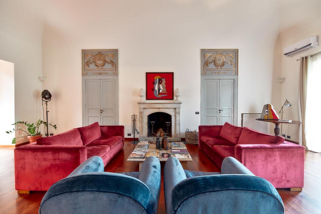 - un salon avec des canapés rouges et une cheminée dans l'établissement L' Hôtellerie Easy Suites, à Palerme