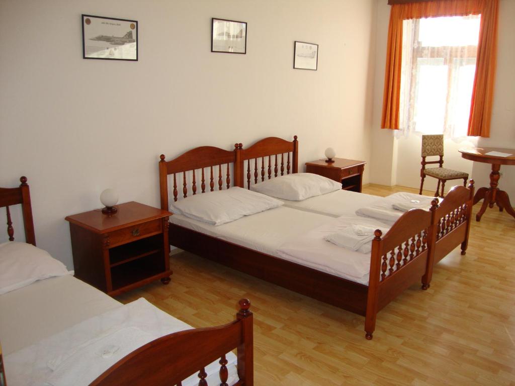 a bedroom with two beds and a table and chairs at Penzion Aviatik in Čáslav