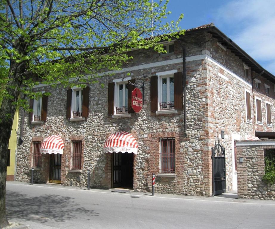 ロナートにあるTrattoria Milaniの赤い看板が貼られた石造りの建物