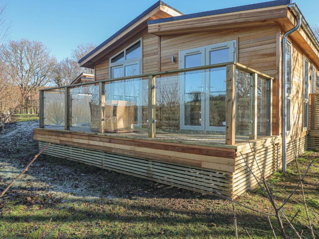 a wooden house with glass windows on a yard at 1 Valley View in Looe