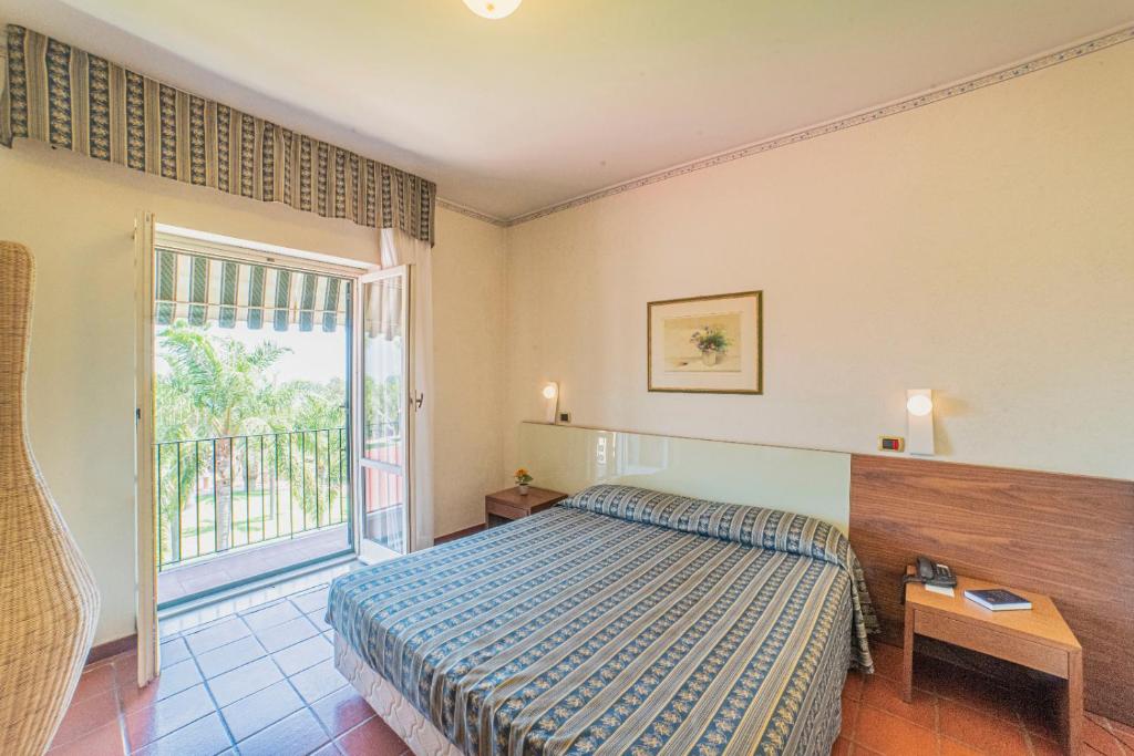 sypialnia z łóżkiem i balkonem w obiekcie Orizzonte Acireale Hotel w mieście Acireale