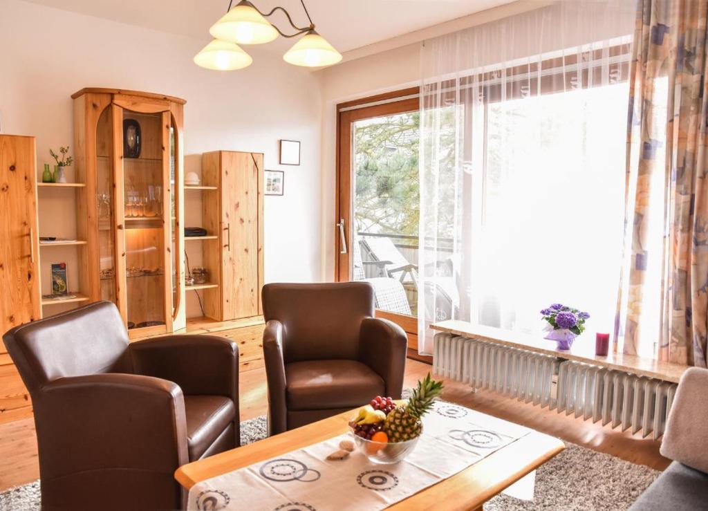 ein Wohnzimmer mit Stühlen und einem Tisch und einem Fenster in der Unterkunft Muschelbank in Büsum