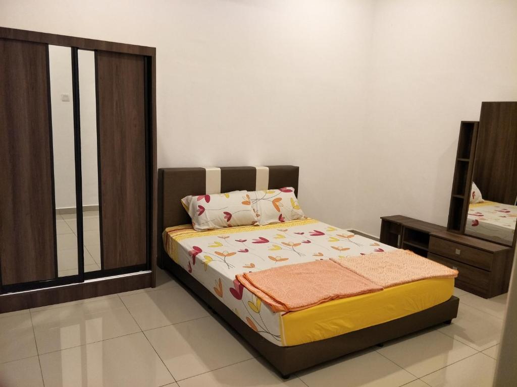 a bedroom with a bed and a mirror at NeoHomeStay Gapam Lestari in Malacca