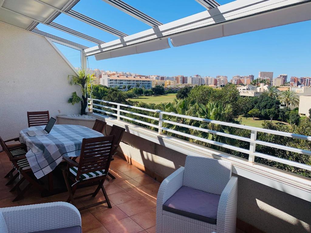 balcón con mesa, sillas y vistas a la ciudad en Terrazas golf, en Alicante