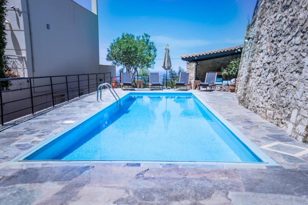 a swimming pool in the middle of a house at Villa Ventus, 40sqm private pool & hot tub! in Roussospítion