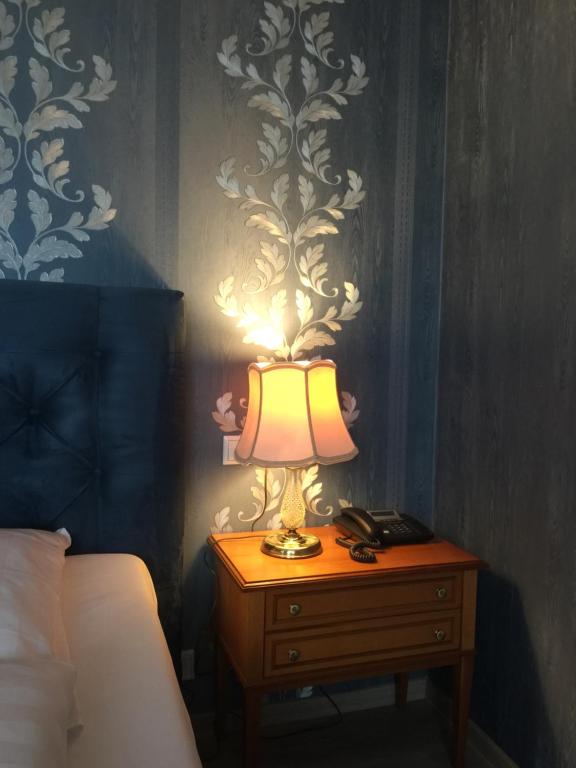a lamp on a night stand next to a bed at Burghotel in Rothenburg ob der Tauber
