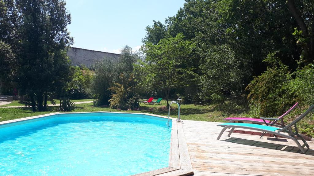 a swimming pool with a bench and a chair next to it at gite ventoux in Loriol-du-Comtat