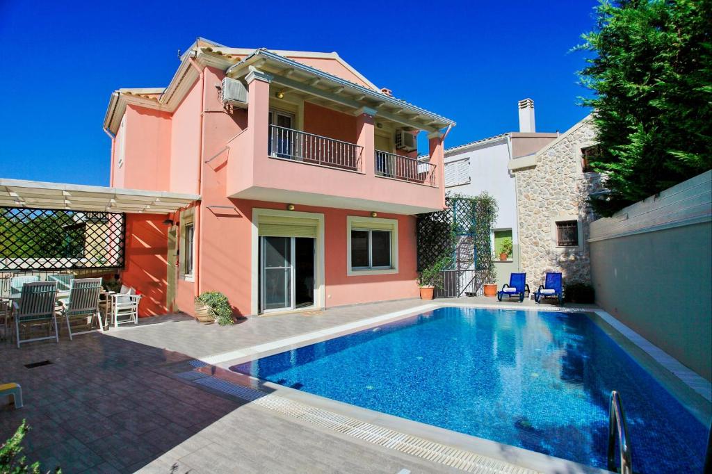 uma casa com piscina em frente a uma casa em The Doctors House em Kassiopi