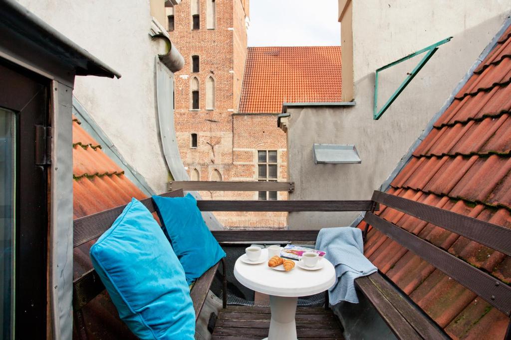 a small table and chairs on a balcony at Elite Apartments Rooftop with a View of the Old Town in Gdańsk