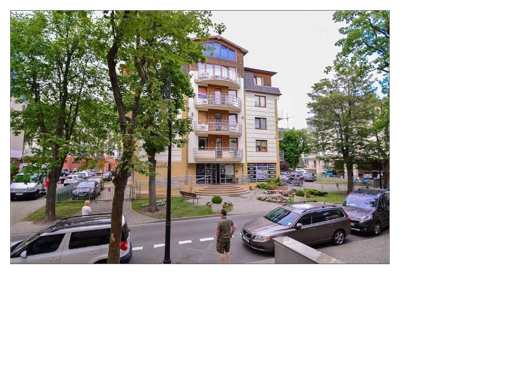 une rue avec des voitures garées devant un bâtiment dans l'établissement Nautilus - Apartament z sypialnią - Parking - ul Orzeszkowej 3, à Świnoujście