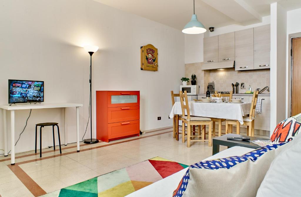 ein Wohnzimmer mit einem Tisch und einer Küche in der Unterkunft Colorato e vivace bilocale in Lucca