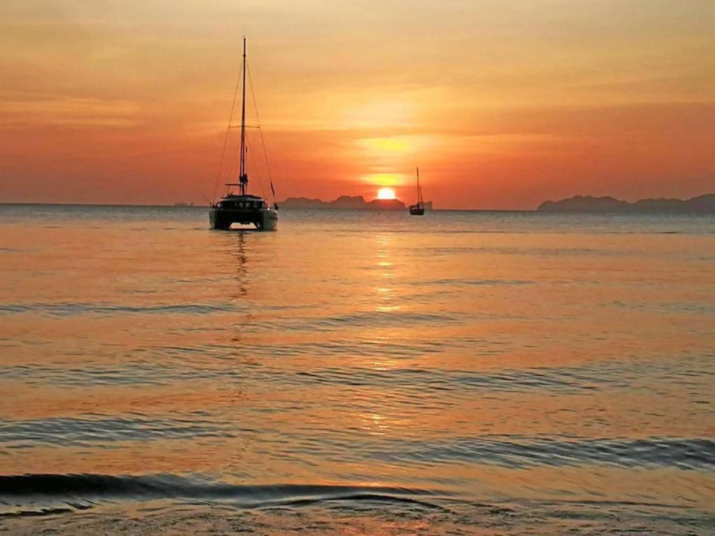 een zeilboot in het water bij zonsondergang bij Koh Jum Delight Beach in Ko Jum