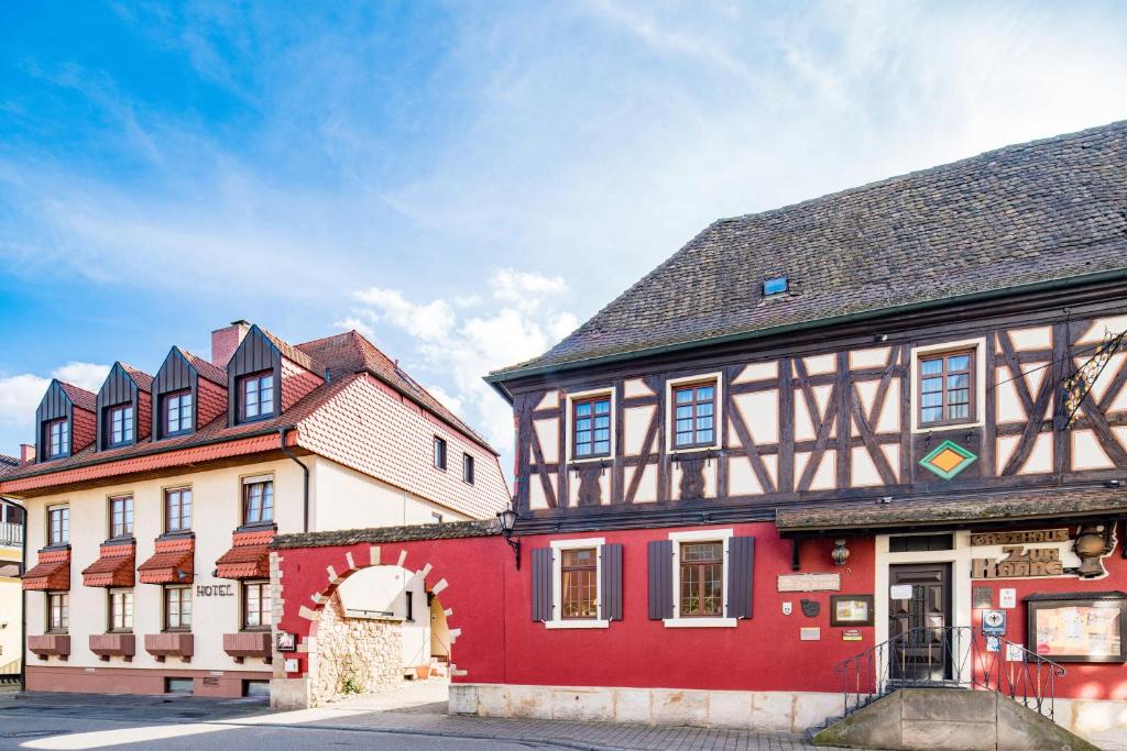 un edificio rojo y blanco junto a otro edificio en Hotel-Restaurant Zur Kanne, en Schifferstadt