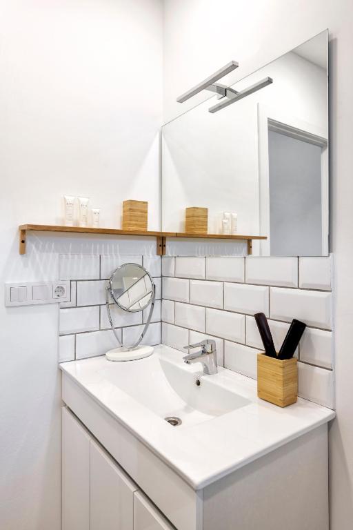 a white bathroom with a sink and a mirror at Hostal Altea House in Altea