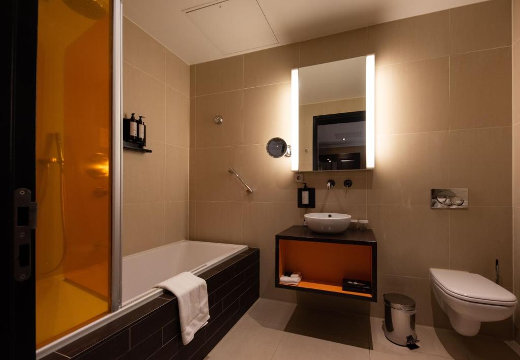 La salle de bains est pourvue d'une baignoire, d'un lavabo et de toilettes. dans l'établissement Hotel & Spa Savarin - Rijswijk, The Hague, à Rijswijk