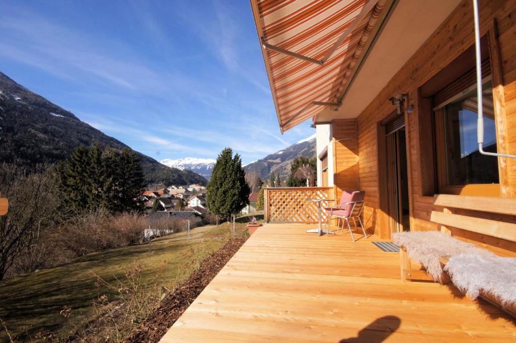 drewniany ganek z widokiem na góry w obiekcie Ferienhaus Sunseitn mit Ruhe und Unabhängigkeit w mieście Obervellach