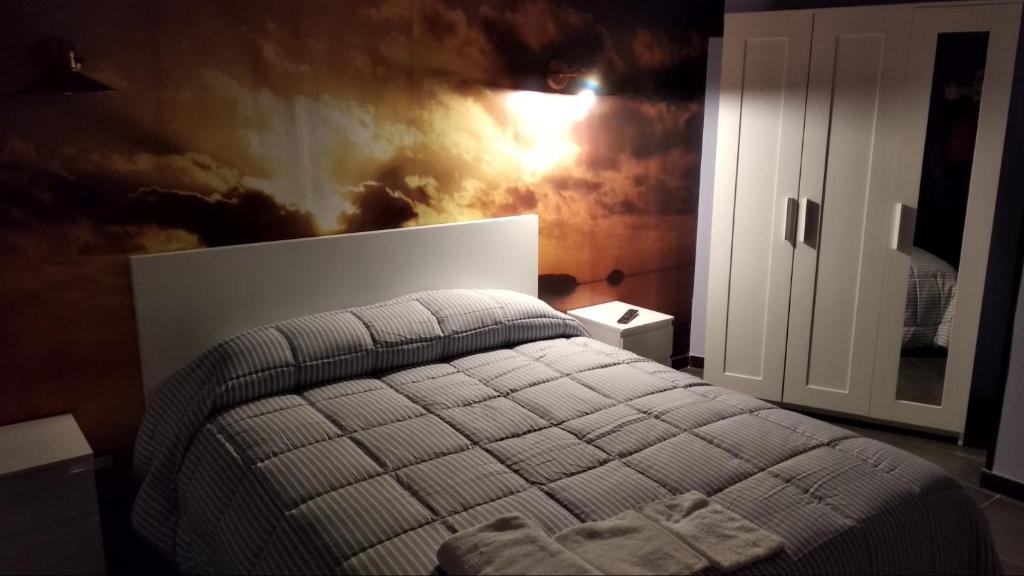 1 dormitorio con 1 cama con un mural de nubes en la pared en B&B Vecchia Darsena, en Augusta
