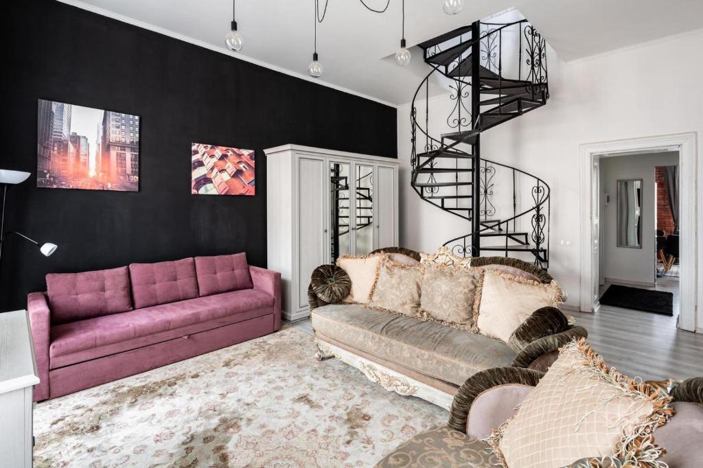 ein Wohnzimmer mit lilafarbenen Sofas und einer Wendeltreppe in der Unterkunft Avangard French Le Ciel Apart in Lwiw