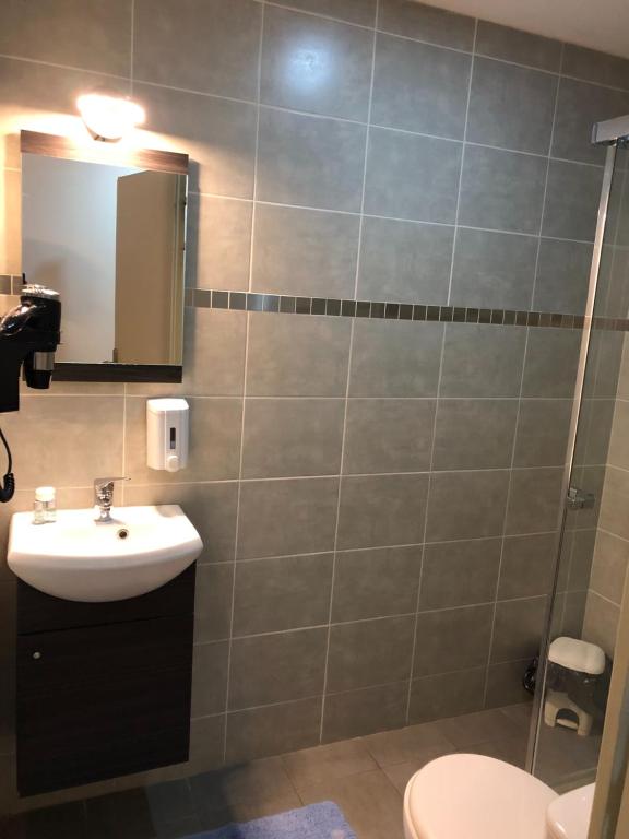 a bathroom with a toilet, sink, and mirror at Hôtel de Ménilmontant in Paris