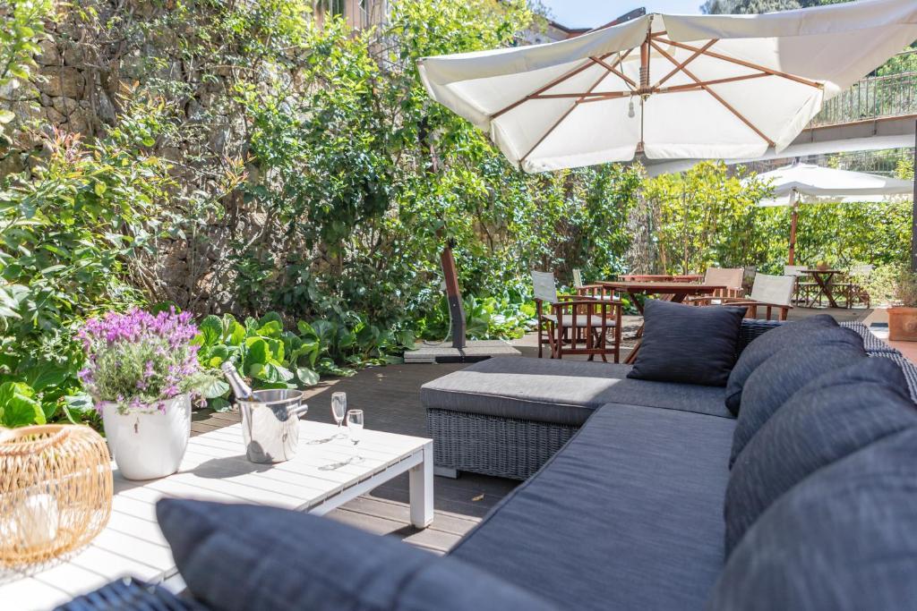 a patio with a blue couch and an umbrella at Baia Blu RTA Residence in Lerici