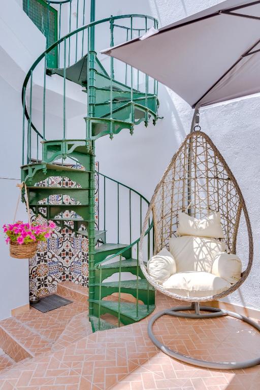 a swinging chair in front of a spiral staircase at Groundfloor in Faro