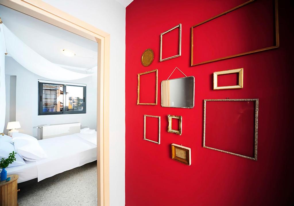 a red wall with pictures on it in a bedroom at Live in Athens, PSYRRI Central Apartments in Athens